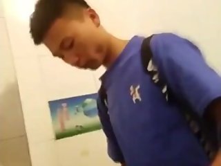 Young Asian boy shakes his dick after piss
